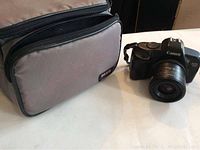 Canon EOS 850 camera with 35-70mm lens next to Image brand padded camera bag