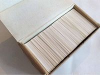 Box containing a large stack of hockey cards, viewed from above showing white card edges.