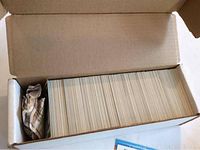 Box filled with hockey cards packed tightly, showing the edges of cards inside a cardboard box.