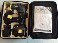 AirMan cordless air compressor in molded insert inside black zippered case, with owner's manual beneath the case lid.