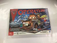 Front view of the Disney Pixar Cars Operation game box showing Mater and other Cars characters with the Operation logo.