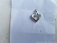 Heart-shaped pendant showing the front side with silver and mother of pearl inlay