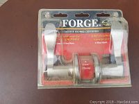 Front view of brand new Forge door handle set in original packaging showing handles and branding.