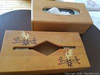 Front angle showing both wooden tissue boxes: one plain, one hand-decorated with rooster and directional arrows design