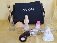Full lot of six vintage Avon perfume bottles and black Avon branded tote bag displayed together
