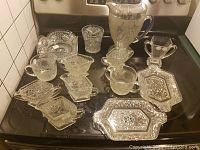 Lot of vintage clear pressed glassware on a stovetop