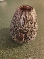 Purple and white mottled glass vase with round opening and textured pattern, photographed upright