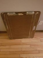 Full view of portable easel board showing its back surface, metal hinges and clips for holding materials.