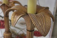 Close-up of the bronze leaf motif base on one lamp showing detailed ridges and texture.