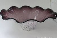 Side view of large art glass bowl showing ruffled edges and speckled pattern