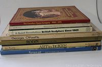 Seven art and reference books stacked on top of each other with titles visible.