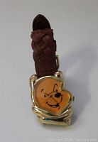 Front view of Disney Winnie the Pooh watch showing character face on the dial and braided brown leather strap.