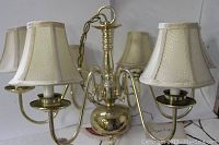 Photo showing the full chandelier with its five brass arms and cream-colored silk shades