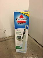 Front of the Bissell Steam Mop box showing the brand, product image, and key feature - Water Purification System for cleaning hard floors.