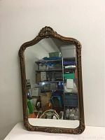 Full front view of the vintage rectangular wall mirror with arched top and ornate frame.