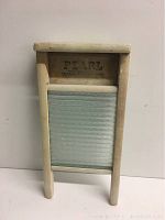 Front view of vintage Pearl washboard showing wood frame and ribbed glass panel.