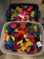 Photo showing one black bin filled with assorted colorful Mega Bloks blocks including multiple sizes and shapes