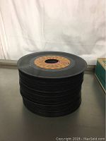 Stack of about 39 45-inch vinyl records, black vinyl with various center labels.