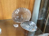 Display of three items: large crystal turkey, medium crystal shell with textured bumps, and small smooth shell possibly Swarovski
