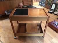 Full view of teak bar cart on casters, showing upper and lower shelves