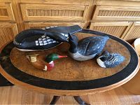 Four wood carved duck decoys displayed on a wooden oval table, showing size and variety