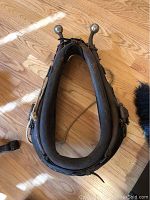 Top view of the leather horse harness with metal finials, showing the padding and overall shape.