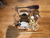 Full lot overview showing assorted tribal decorative items including brooms, drums, wall hangings, and carved pieces.