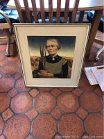 Full view of the framed print showing the woman holding a potted plant against a landscape background.