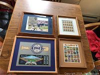 Overview photo of all four framed baseball memorabilia items on table