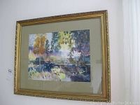 Framed watercolor painting depicting a colorful landscape scene, signed Oliver Holden at bottom right, in a gold ornate frame.