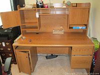 Desk overall front view shows desk surface with items removed, left lower cabinet open, hutch cabinets open displaying shelves inside.