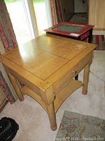 Nautica style light wood side table with tile-patterned top, square shape, under shelf, and rounded legs.