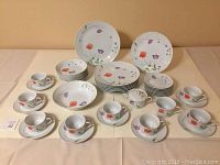 Full set arranged on table showing all 45 pieces, including plates, bowls, cups, saucers, sugar bowl with lid, and creamer, displaying floral pattern.