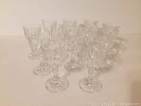 Front view of all 12 clear dessert wine glasses grouped together, showing faceted bowl and stem details.