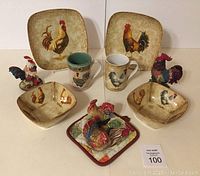 Full set of rooster-themed ceramic dishware and figurines shown on table.
