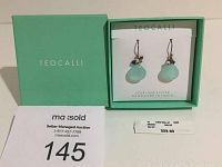 Teocalli sterling silver earrings in branded box with mint green lid inside white card insert showing brand and 'Handmade in India' text.