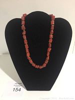 Full view of the coral and turquoise bead necklace displayed on a black velvet bust.