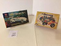 Two vintage car model kit boxes shown side by side on a white surface: 1935 Classic Auburn Speedster and 1901 Darracq.
