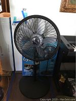 Front view of Lasko Cyclone 18-inch standing fan on round base with remote control.