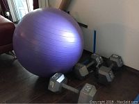 Overall lot showing the purple exercise ball beside three hex dumbbells of various weights: 40 lbs, 35 lbs, 30 lbs.
