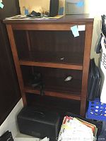 Wooden bookcase showing two adjustable shelves and overall structure including visible wear.
