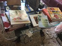 Cook books displayed on a glass coffee table, showing multiple titles and different sizes.