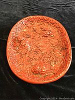 Top view of the oval resin tray showing intricate grapevine and leaf relief in reddish tones.