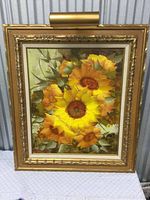 Framed oil on canvas painting of sunflowers in yellow and orange hues accented by green leaves.