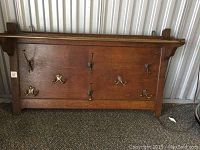 Front view of antique oak wall coat rack showing the panel and all hooks.