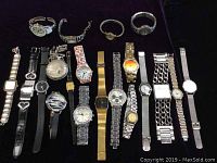 Photo showing full lot of 20 various quartz watches with different bands and styles on black background.