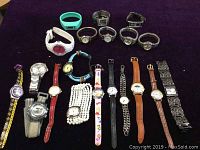 Photo showing 20 assorted quartz wrist watches on black fabric background