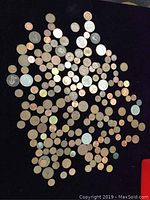 Photo of assorted collector coins on black fabric background showing various British and Canadian coins.