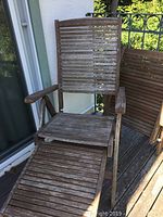First teak deck chair showing slatted backrest, seat, armrests, and footrest extended.