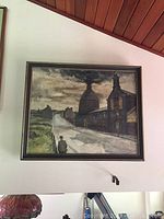 Full view of framed painting depicting urban street and industrial buildings under cloudy sky